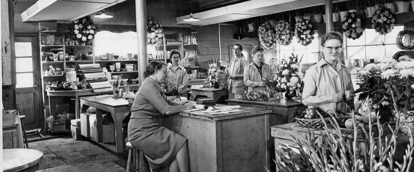 Group of people sitting in a floral shop amongst various types of flowers shopping